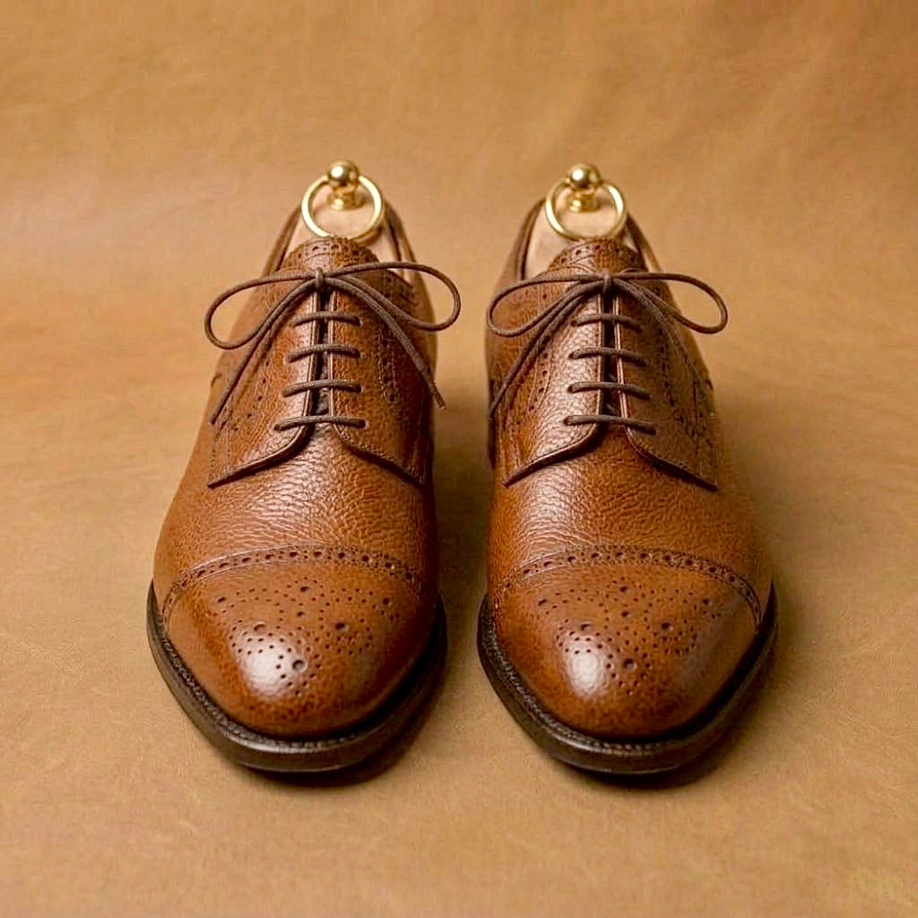 Tan semi brogue derby shoes with a straight toe cap and brogue perforations