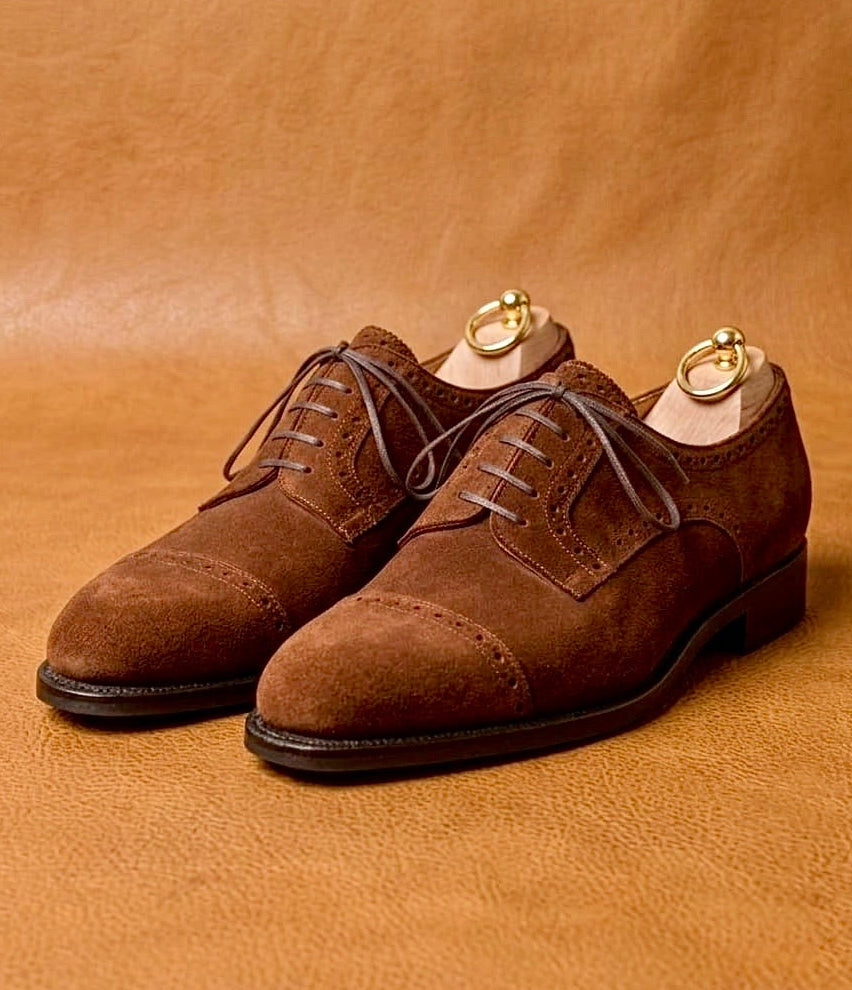 Brown suede derby shoes with open lacing and a welted leather sole