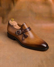 Side tassels set on the quarter of a tan and brown monk strap