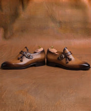 Buckle and strap across the instep of a tan monk strap shoe