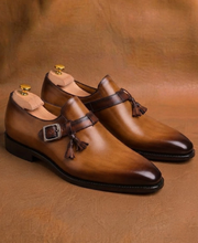 Men's tan and brown tassel monk strap shoes, three quarter view
