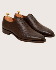Man wearing dark brown ostrich wholecut oxford with a navy suit
