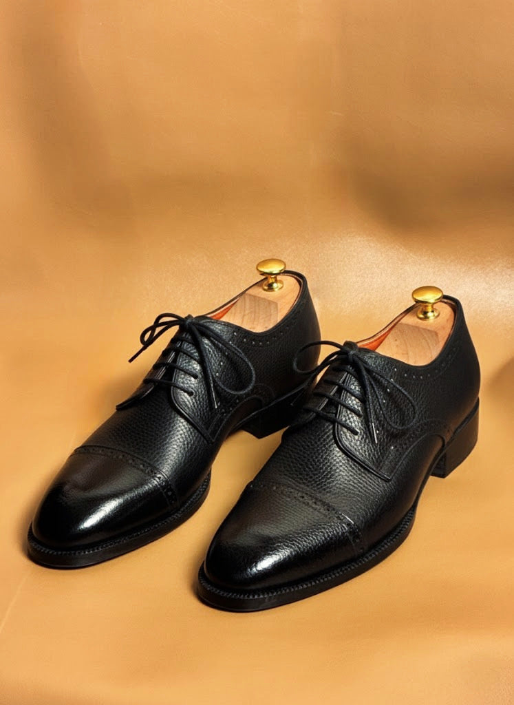 Men's black pebble grain derby boots, three quarter view
