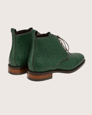Ankle height and flat heel of a men's green stingray derby boot