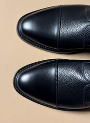 Welt stitching around the sole of a black leather boot